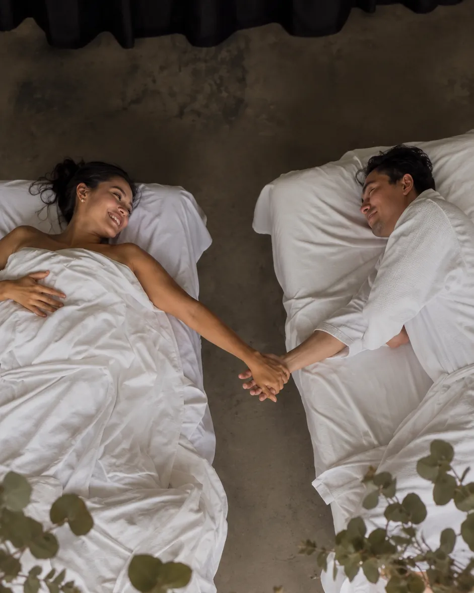 Couple holding hands on their massage tables after a couples massage at Casa Botica